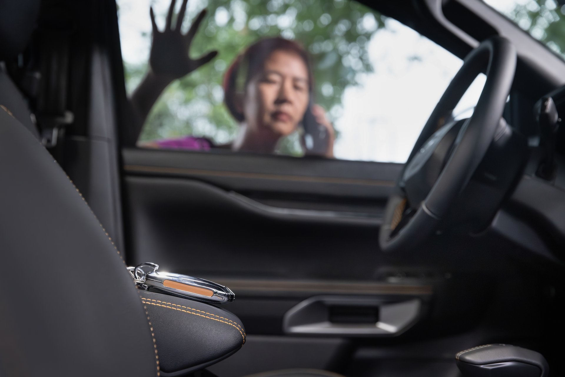 Senior woman retrieving keys from locked car - automotive locksmith service
