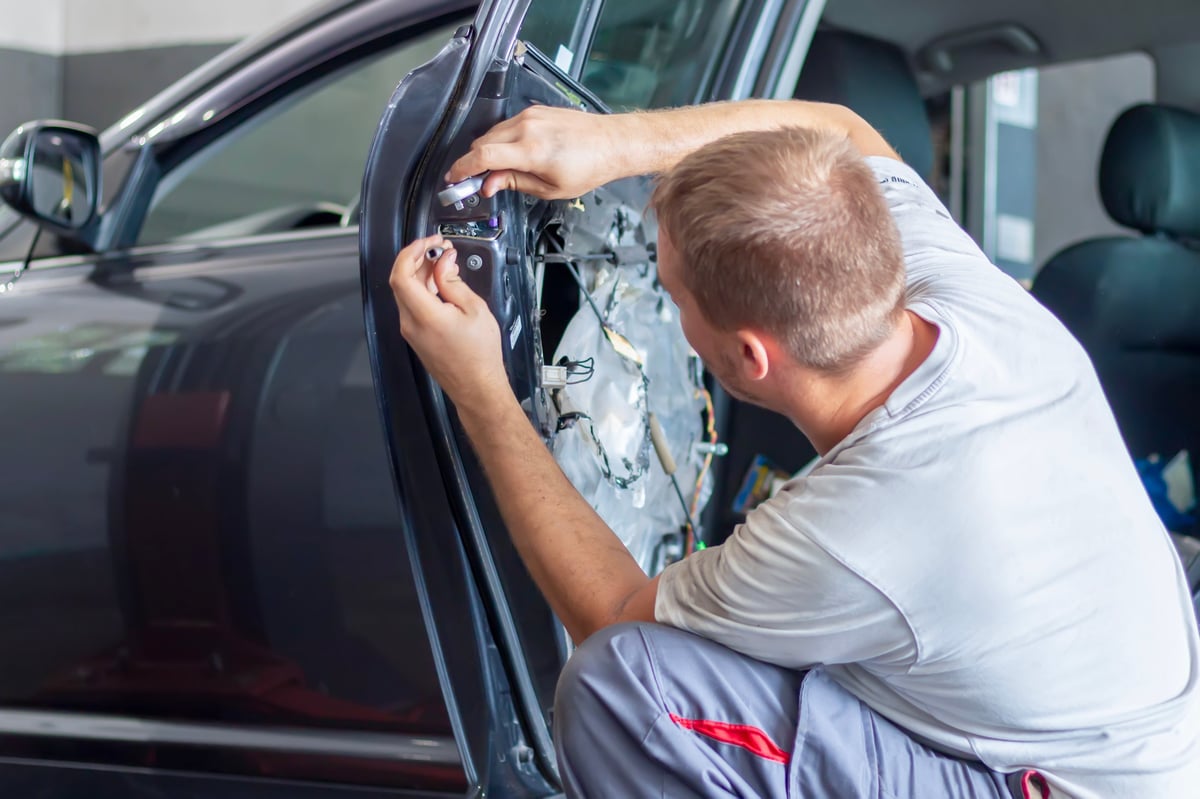Car mechanic fixing vehicle door lock